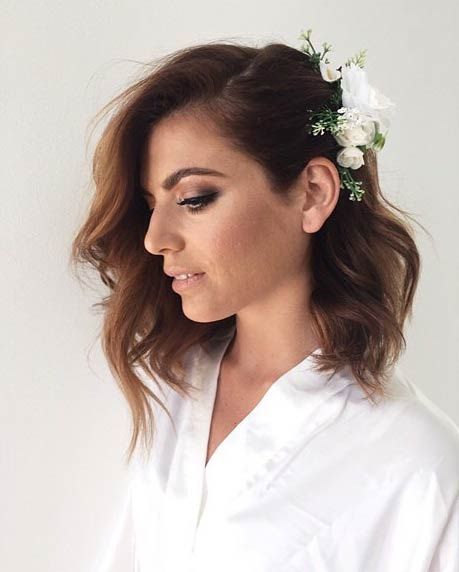 Open wavy hairstyle with floral accessory